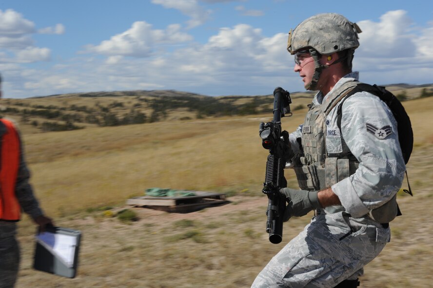 Senior Airman Brandon Lepkowski, 5th Security Forces Squadron Global Strike Challenge team member, runs to his position during the shooting portion of the competition at Camp Guernsey, Wyo., Sept. 23, 2014. Lepkowski fired 40MM grenades at bunkers set at a variety of distances on the range as his team mates cheered him on. (U.S. Air Force photo/Senior Airman Stephanie Morris)