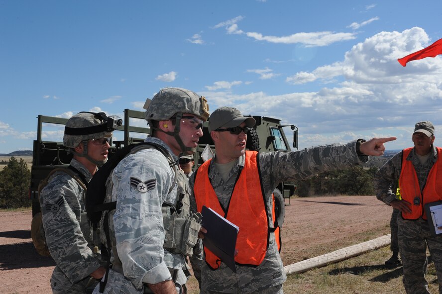 Senior Airman Brandon Lepkowski, 5th Security Forces Squadron Global Strike Challenge team member, listens to directions during the shooting portion of the competition at Camp Guernsey, Wyo., Sept. 23, 2014. Lepkowski fired 40MM grenades at bunkers set at a variety of distances on the range as his teammates cheered him on. (U.S. Air Force photo/Senior Airman Stephanie Morris)