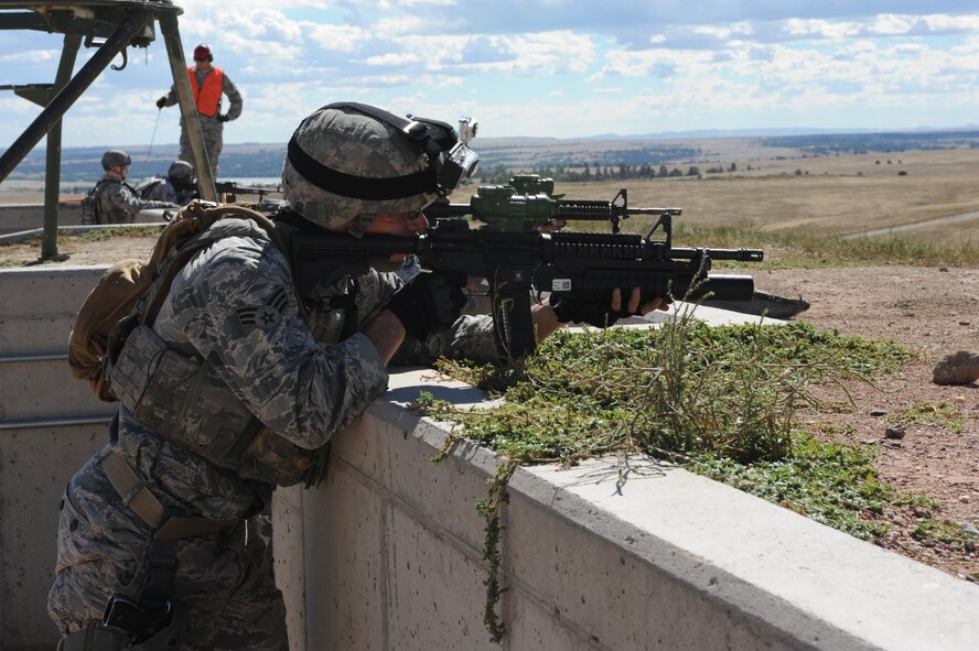 Senior Airman Kevin Swen, 5th Security Forces Squadron Global Strike Challenge team member, rides in the back of a truck during the shooting portion of the competition at Camp Guernsey, Wyo., Sept. 23, 2014. During firing, the team took aim at pop-up targets positioned at various distances on the range. (U.S. Air Force photo/Senior Airman Stephanie Morris)