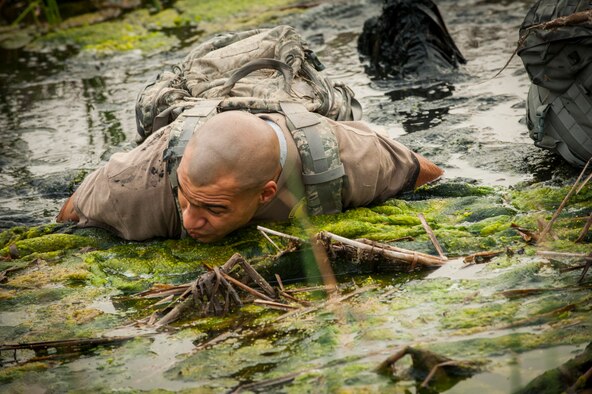 A Team Minot Airman low-crawls through a creek during the GORUCK Light Team Cohesion Challenge on Minot Air Force Base, N.D., Sept. 24, 2014. The five-hour ruck march included special operations-based obstacles and promoted teamwork. (U.S. Air Force photo/Airman 1st Class Apryl Hall)