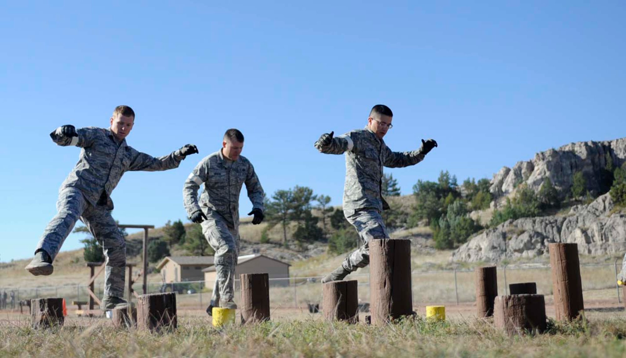 Senior Airman Tyler Wright, Tech. Sgt. James Udvare and Airman 1st Class Aaron Lynch, 28th Security Forces Squadron defenders, run through a balancing obstacle during the Global Strike Challenge competition at Camp Guernsey, Wyo., Sept. 25, 2014. The obstacle course tested the team’s physical abilities while challenging their mental awareness during high stress conditions. (U.S. Air Force photo by Tech. Sgt. Jerry Fleshman/Released)