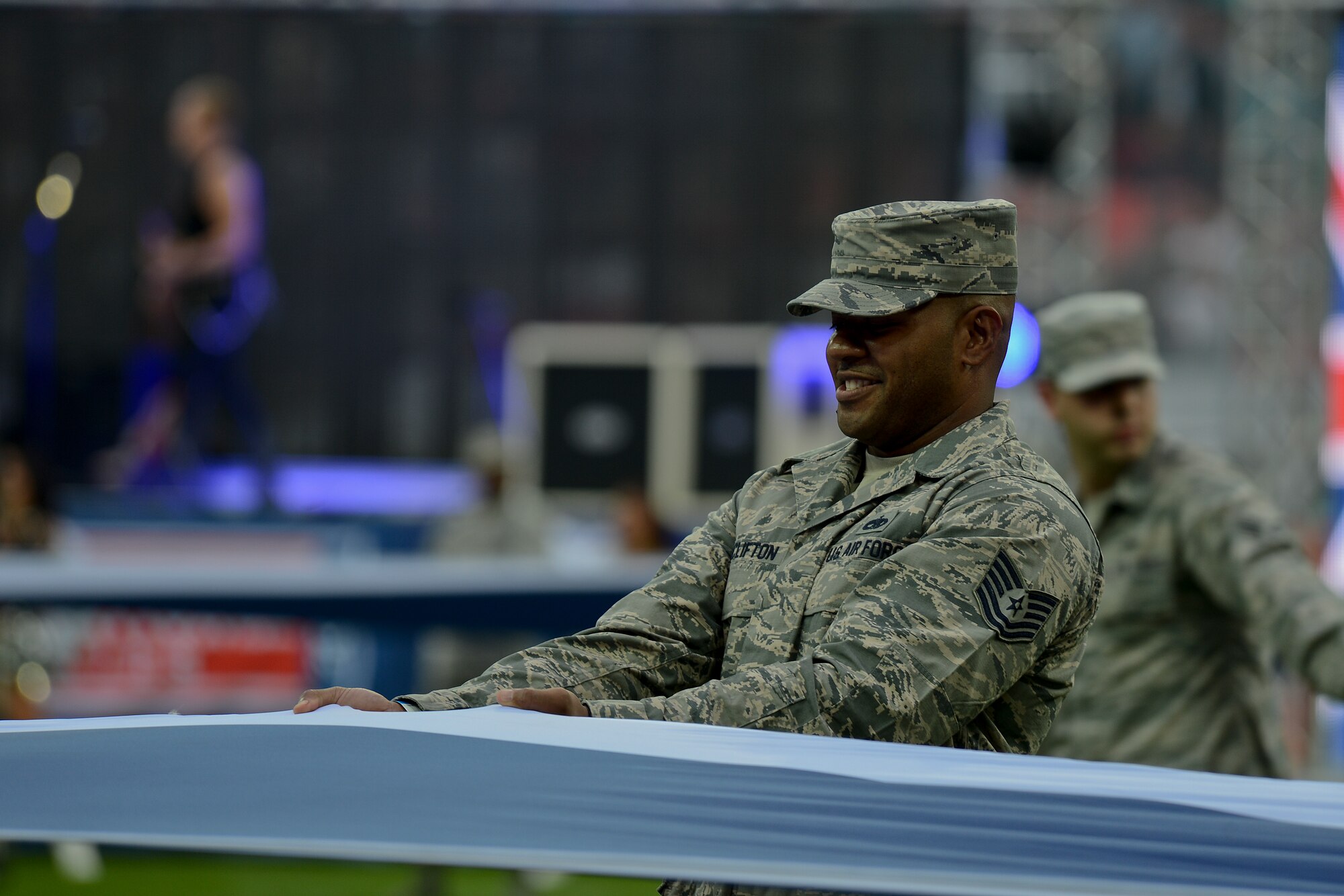 Tech. Sgt. Brendan Clifton, 48th Equipment Maintenance Squadron aircraft structural maintenance craftsman, holds a U.K. flag before the Miami Dolphins – Oakland Raiders football game in London on Sept. 28, 2014. The game was the first of three international NFL games that will be played this season at Wembley Stadium. As part of the pregame ceremony, the 48 Fighter Wing Airmen presented U.S. and U.K. flags as a sign of the continued cooperation between U.S. visiting forces and their U.K. hosts. (U.S. Air Force photo by Airman 1st Class Trevor T. McBride)