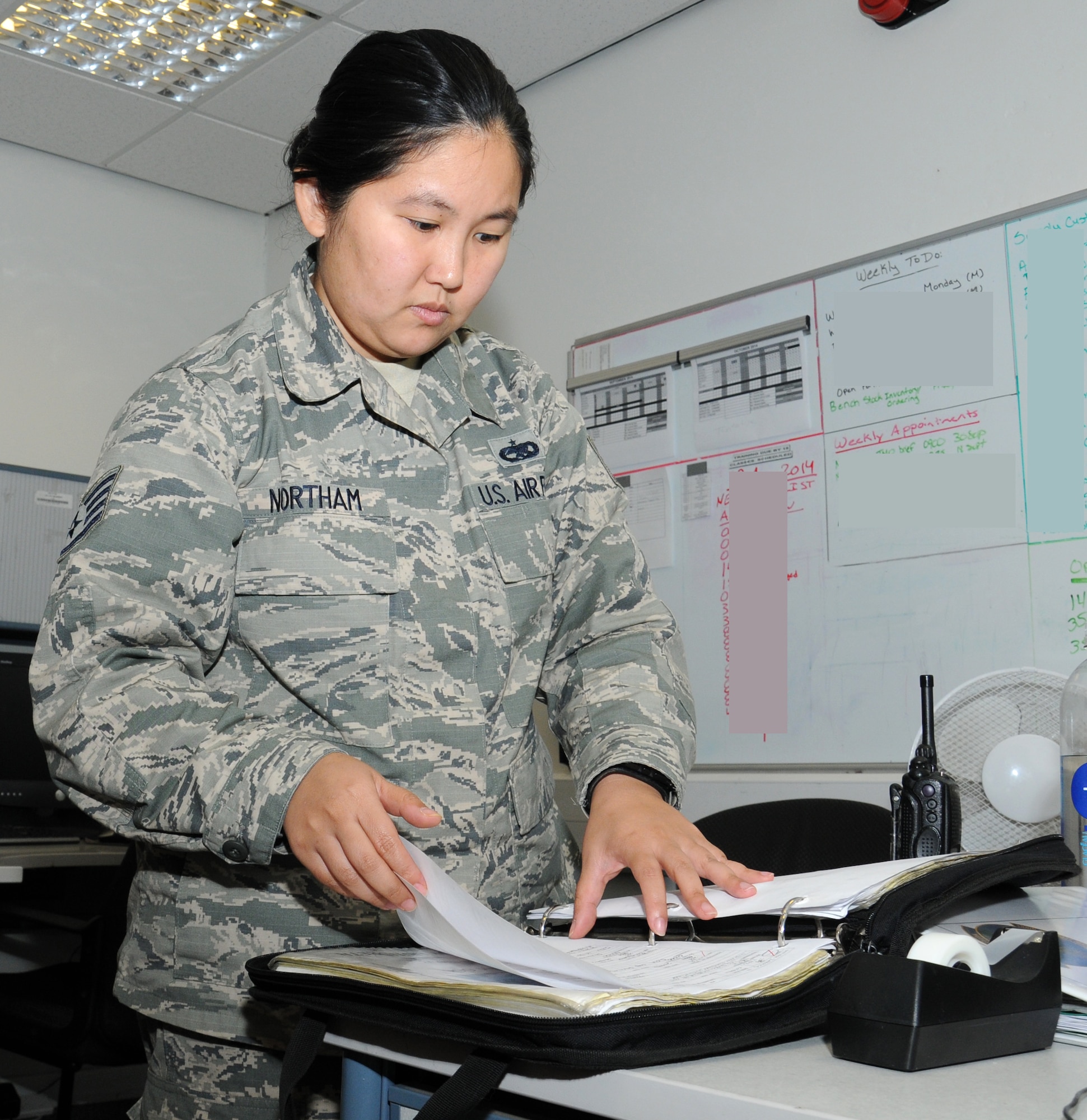 U.S. Air Force Staff Sgt. Erica Northam, 100th Aircraft Maintenance Squadron debrief and supply focal point technician from Juneau, Alaska, checks aircraft forms Sept. 12, 2014, on RAF Mildenhall, England. The forms contain a record of everything pertaining to an aircraft including items that have been fixed, how many hours it’s flown and engine cycles . (U.S. Air Force photo/Gina Randall/Released)