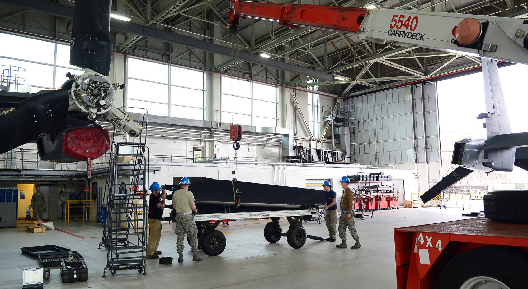 Members of the 352nd Special Operations Maintenance Squadron guide a removed blade from a CV-22B Osprey onto a blade trailer Sept. 23, 2014, on RAF Mildenhall, England. The blade was removed from one CV-22B to improve the ice protection system on another aircraft. It was also repainted as preventative maintenance while it was removed.  (U.S. Air Force photo/Airman 1st Class Jonathan Light/Released)