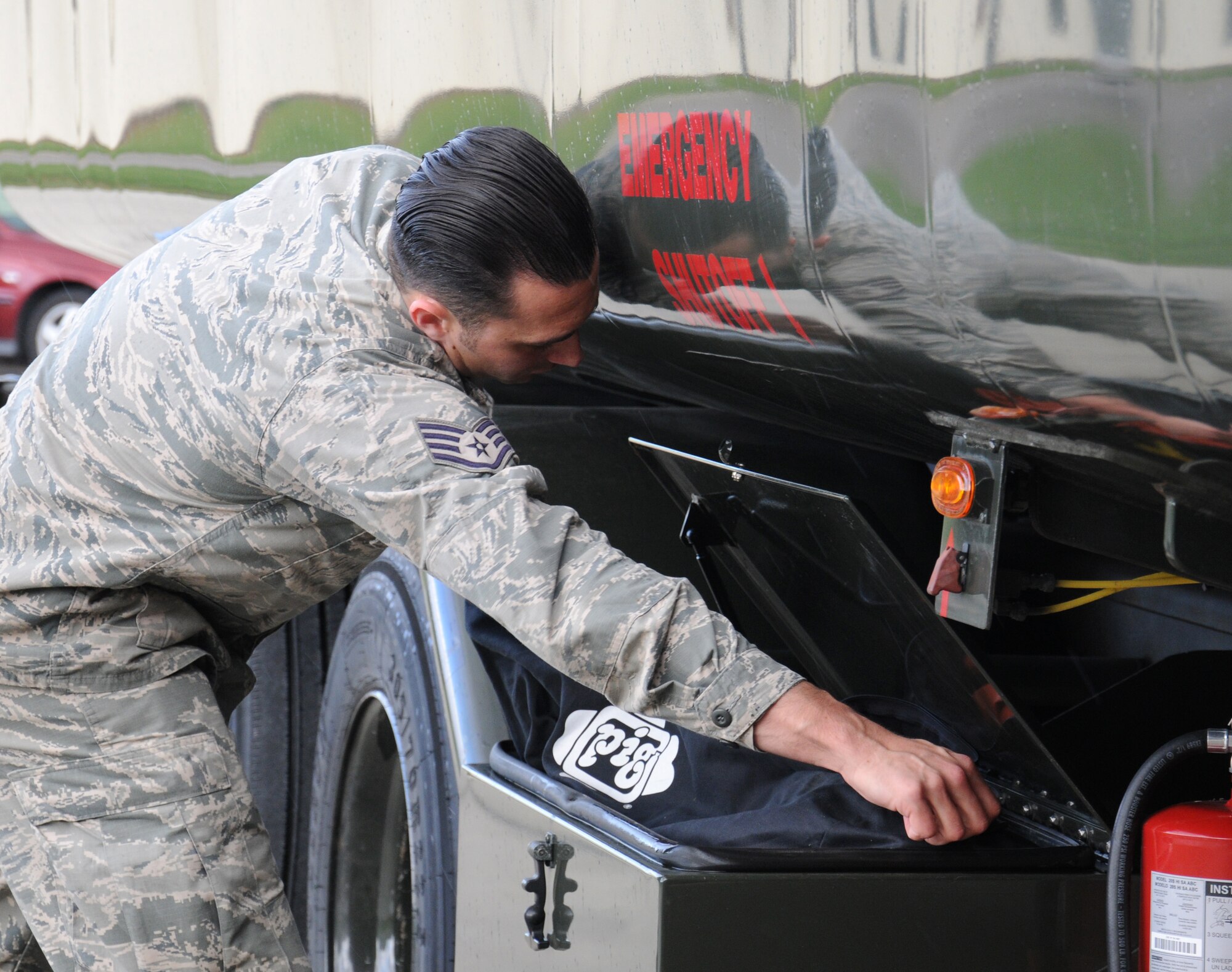 U.S. Air Force Staff Sgt. Zachary Kiniry, 100th Logistics Readiness Squadron Fuels training and support supervisor from Claremont, N.H., opens a spill kit prior to deploying a spill pool Sept. 24, 2014, on RAF Mildenhall, England. Kits are placed in the foreign object damage box on each fuel truck so they can be deployed by a first responder Airman in the event of a fuel spill. (U.S. Air Force photo/Gina Randall/Released)