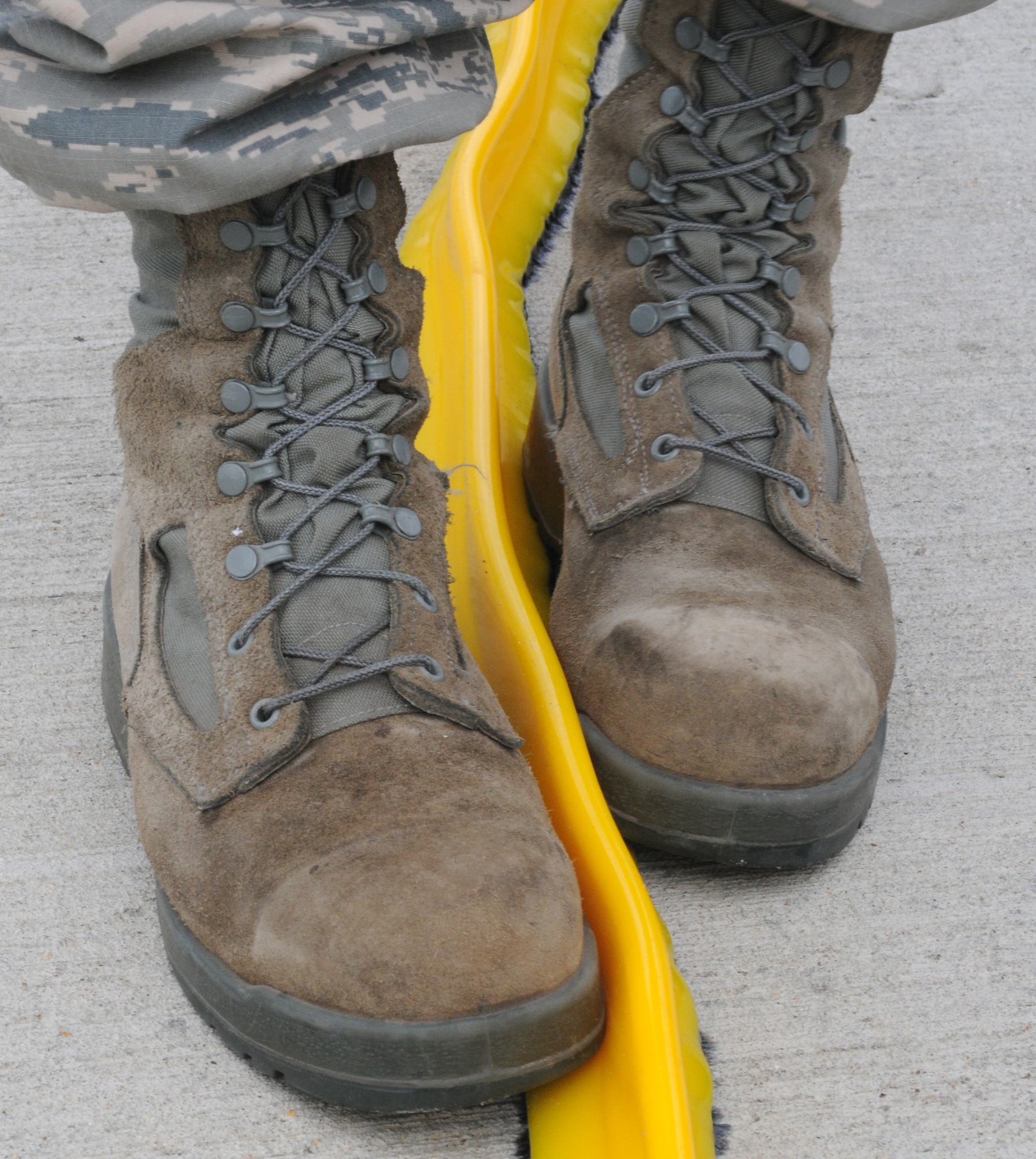 U.S. Air Force Staff Sgt. Zachary Kiniry, 100th Logistics Readiness Squadron Fuels training and support supervisor from Claremont, N.H., secures a spill dyke to the ground Sept. 24, 2014, on RAF Mildenhall, England. Once secured to the ground, they become liquid resistant to prevent any fuel from passing and entering the environment. (U.S. Air Force photo/Gina Randall/Released)