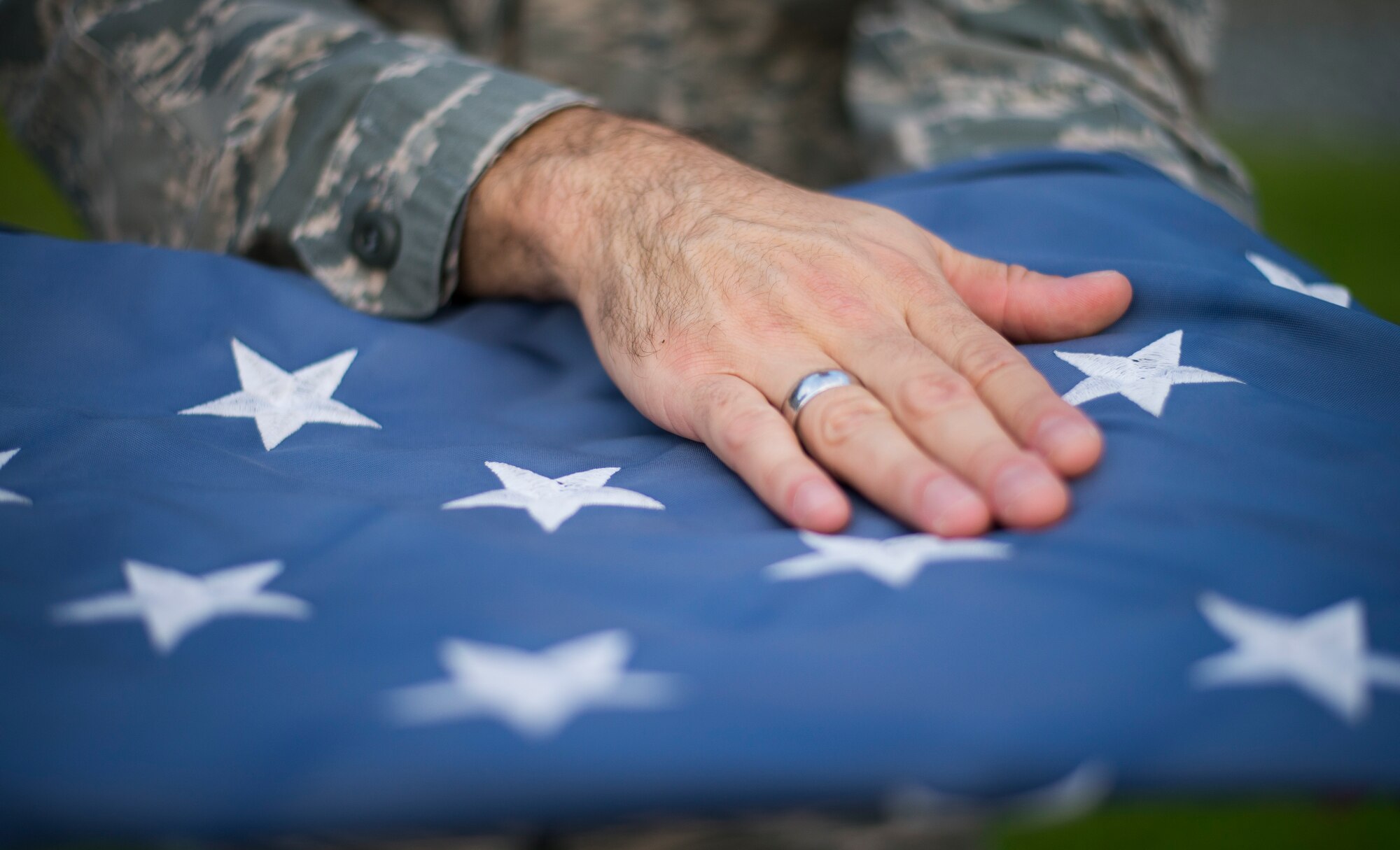 A hand rests on the flag during a retreat ceremony at Yokota Air Base, Japan, Sept. 26, 2014. The retreat ceremony serves a twofold purpose. It signals the end of the official duty day as well as a ceremony for paying respect to the flag. (U.S. Air Force photo by Staff Sgt. Chad C. Strohmeyer)(Released)