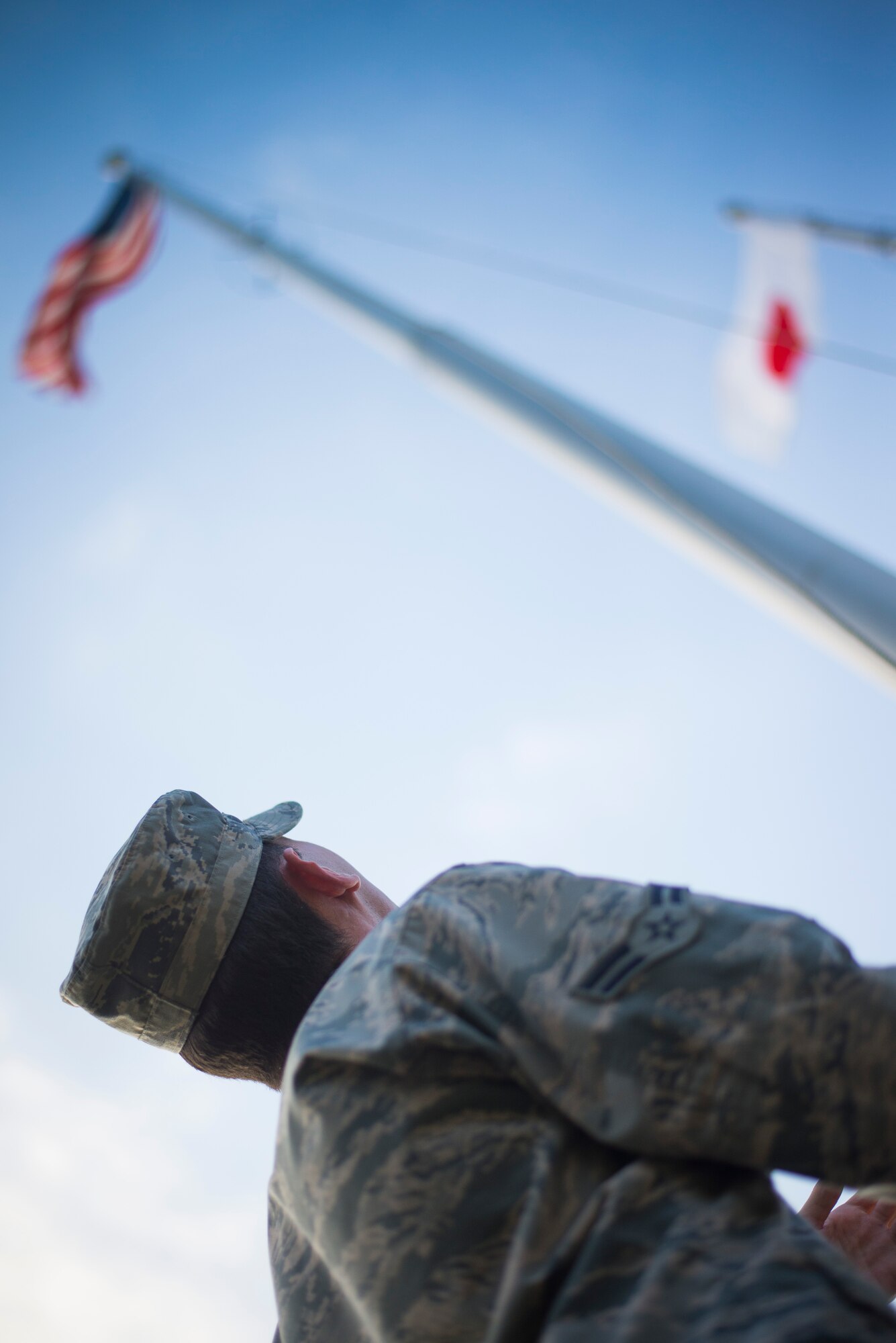 Airman 1st Class Corey Durrance, 374th Force Support Squadron, assists in lowering the flag during a retreat ceremony at Yokota Air Base, Japan, Sept. 26, 2014. The retreat ceremony serves a twofold purpose. It signals the end of the official duty day as well as a ceremony for paying respect to the flag. (U.S. Air Force photo by Staff Sgt. Chad C. Strohmeyer)(Released)