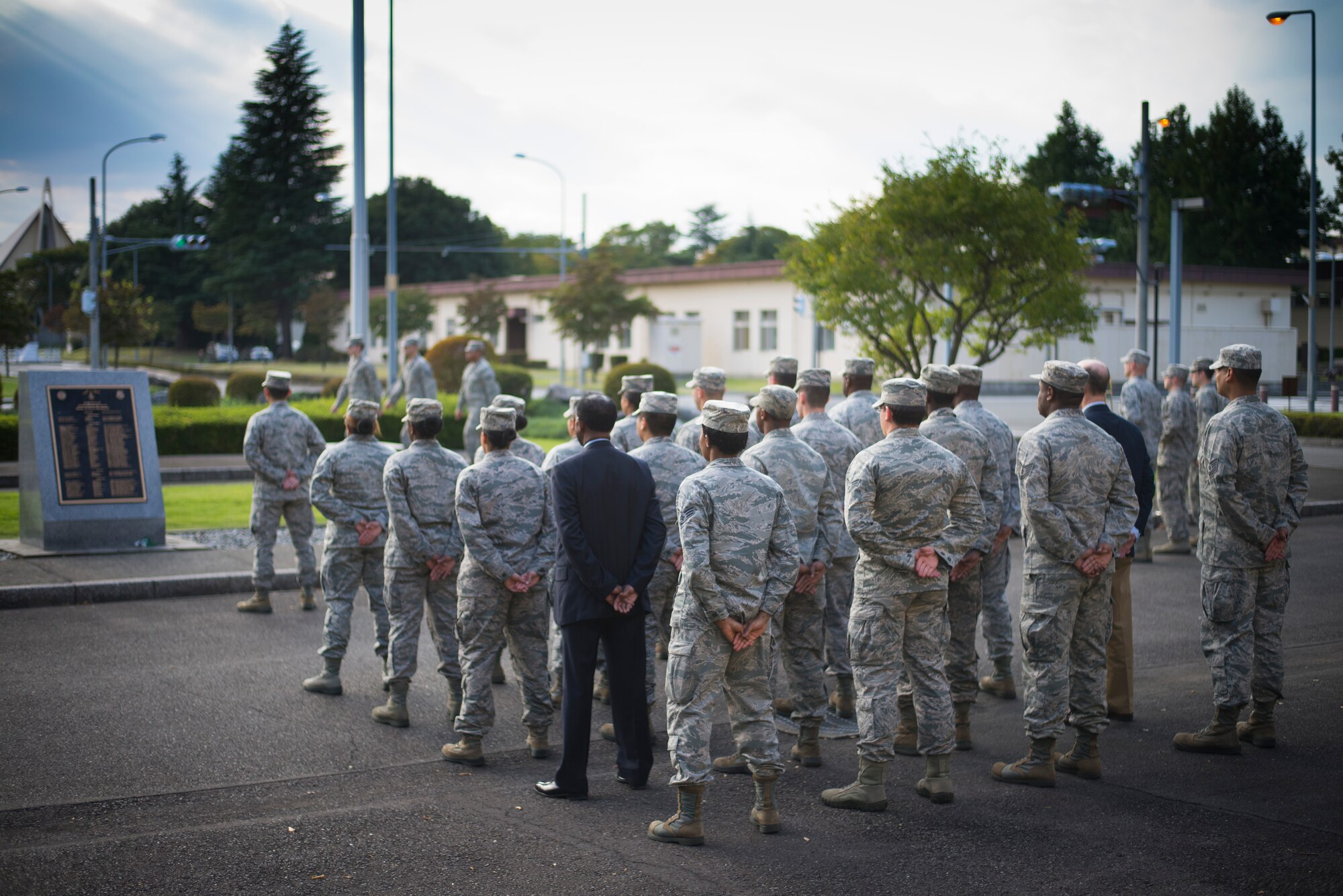 Members from the 374th Force Support Squadron stand at parade rest prior to the start of a retreat ceremony at Yokota Air Base, Japan, Sept. 26, 2014. The retreat ceremony serves a twofold purpose. It signals the end of the official duty day as well as a ceremony for paying respect to the flag. (U.S. Air Force photo by Staff Sgt. Chad C. Strohmeyer)(Released)