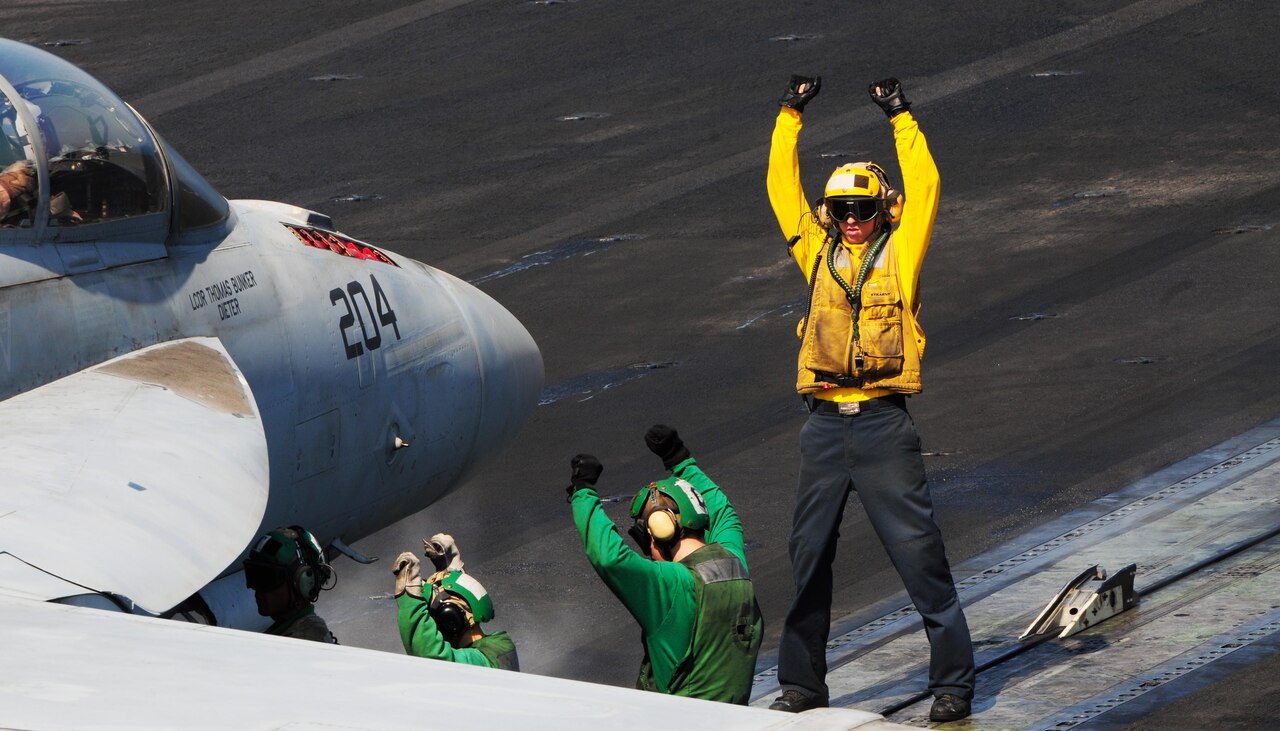U.S. Navy Petty Officer 3rd Class Andrew Matte directs an F/A-18F Super Hornet as it prepares to launch from the flight deck of the aircraft carrier USS George H.W. Bush in the Persian Gulf Sept. 22, 2014. U.S. Navy photo by Petty Officer 3rd Class Joshua Card