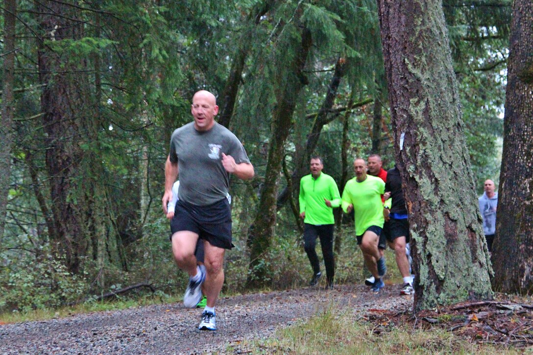 Guardsmen and state employees run along a path around the perimeter of the Washington National Guard’s headquarters during a suicide prevention awareness run on Camp Murray, Wash., Sept. 26, 2014.