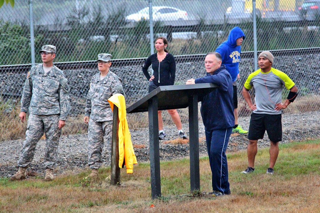 Army Maj. Gen. Bret D. Daugherty, foreground, adjutant general for the Washington National Guard, Army Staff Sgt. Adam Zangenberg, left, Army Sgt. 1st Class Melinda Heikkinen, center left, and Army Sgt. 1st Class Ron Cardenas, right, watch participants in a suicide prevention awareness run on Camp Murray, Wash., Sept. 26, 2014. Zangenberg, a suicide prevention program manager, Heikkinen, a sexual assault coordinator, and Cardenas are assigned to the Washington National Guard.