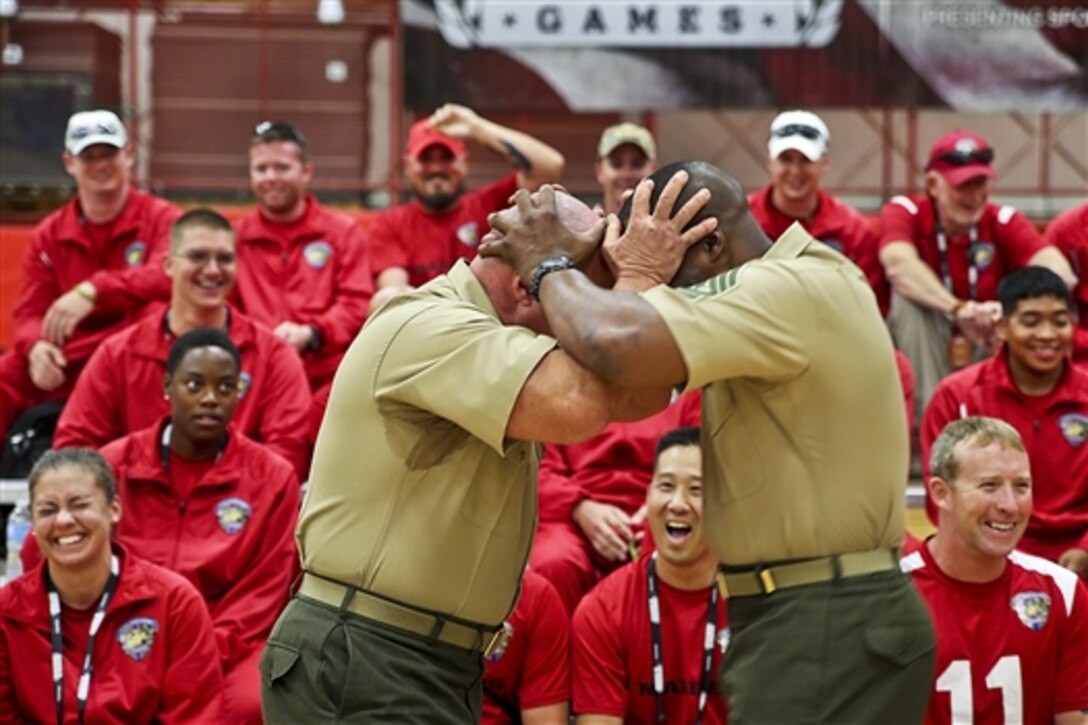 Marine Corps Col. T. Shane Tomko, left, and Marine Corps Sgt. Maj. Michael T. Mack butt heads after giving a motivational speech to the Marine team before members play the first sitting volleyball kick-off sport of the 2014 Warrior Games in Colorado Springs, Colo., Sept. 28, 2014. The team includes active duty and veteran wounded, ill and injured Marines attached to or supported by the Wounded Warrior Regiment. Tomko is the regiment's commanding officer and Mack is the unit's sergeant major. 