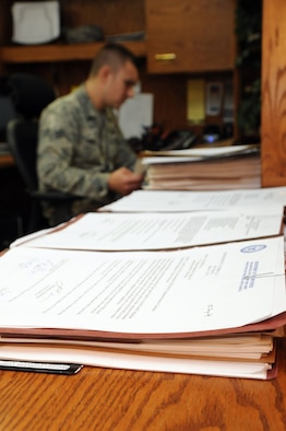 Senior Airman Alexander Ponusky, 319th Contracting Flight contract specialist, reviews paperwork in the 319th CONF office on Grand Forks Air Force Base, N.D., Sept. 25, 2014. The 319th CONF creates and oversees contracts ranging from small purchases of supplies to multimillion dollar construction projects. (U.S. Air Force photo/Staff Sgt. David Dobrydney)