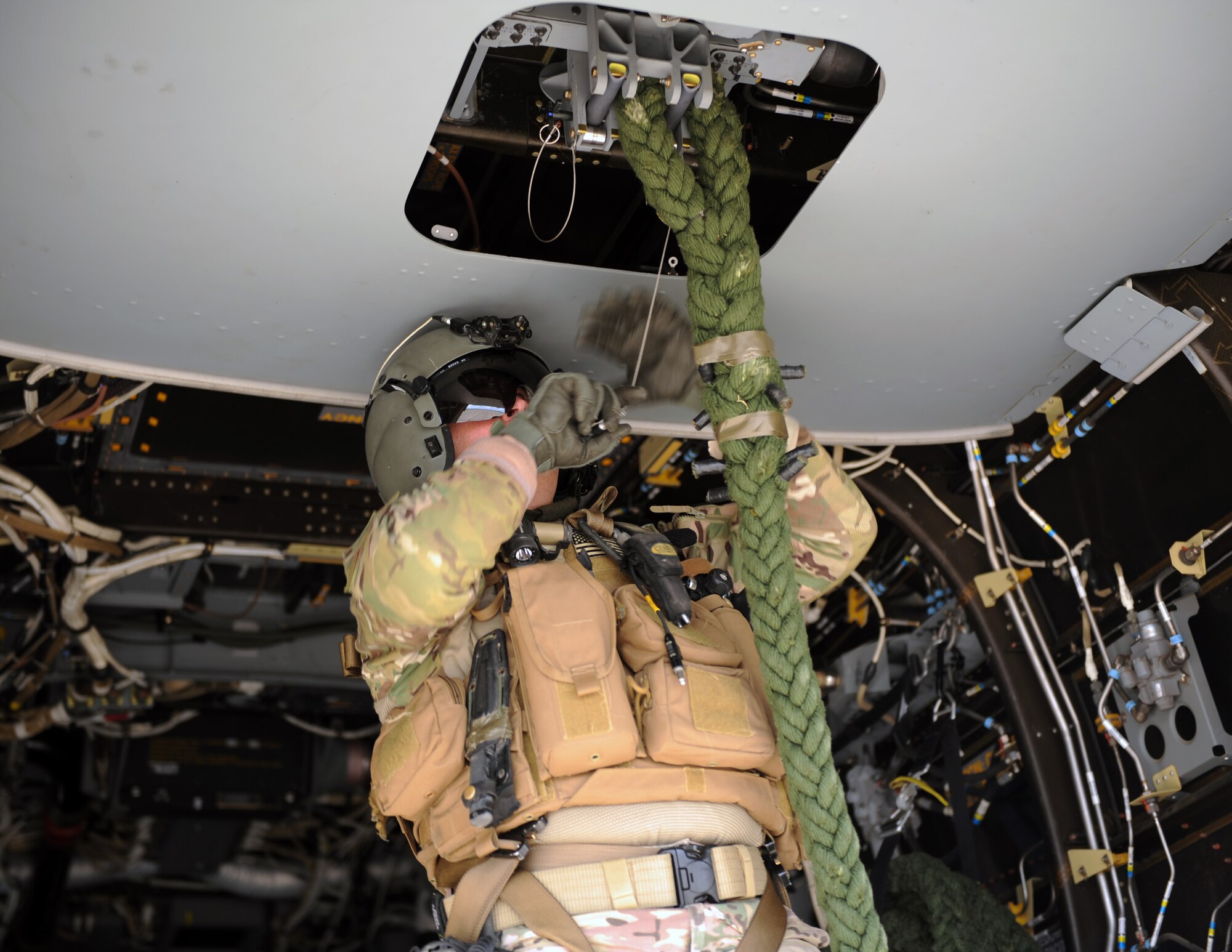 U.S. Air Force Senior Master Sgt. Erik Davis, 7th Special Operations Squadron CV-22B Osprey special mission aviator, connects the heavy rope prior to the Special Tactics Airmen who will infiltrate an area during training using the Fast Rope Insertion Extraction System, March 25, 2015, at RAF Sculthorpe in Norfolk, England. (U.S. Air Force photo by Tech. Sgt. Stacia Zachary)