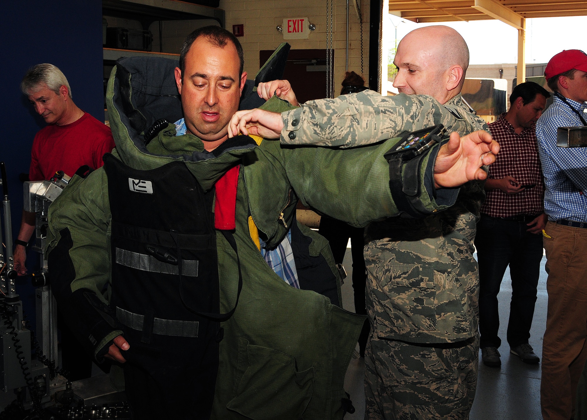 Master Sgt. Stephen Hunter, 944th Civil Engineer Squadron explosive ordinance disposal program manager, helps Mr. Jack Weiner, Arizona Chapter Entrepreneurs Organization member and business owner, put on a bomb suit March 27 during the Entrepreneurs Organization tour at Luke Air Force Base, Ariz. (U.S. Air Force photo by Tech. Sgt. Louis Vega Jr.)
