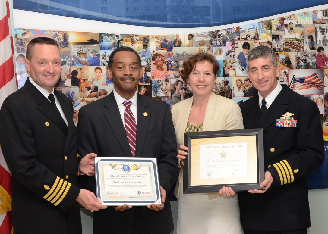 (From left to right) Naval Hospital Jacksonville, Fla., Commanding Officer Capt. John Le Favour, Ph.D.; Assistant Secretary of Defense for Health Affairs Jonathan Woodson, M.D.; Prevention Partners Strategic Alliances Director Annie Thornhill, M.P.H.; and NH Jacksonville Ambassadors for Health Champion Capt. Joseph McQuade, M.D., celebrate NH Jacksonville’s Ambassadors for Health Gold Star recognition for achieving the highest national standards for a tobacco-free workplace. 