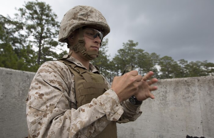 Private First Class Nathan Culver, an engineer equipment mechanic with Engineer Support Company, 8th Engineer Support Battalion, removes the safety pins from an M67 fragmentation grenade in preparation to throw it aboard Camp Lejeune, N.C., March 27, 2015. The training ensured junior Marines still remembered how to handle a live grenade, and also served as a refresher for more seasoned Marines who haven’t used these skills in quite some time. 