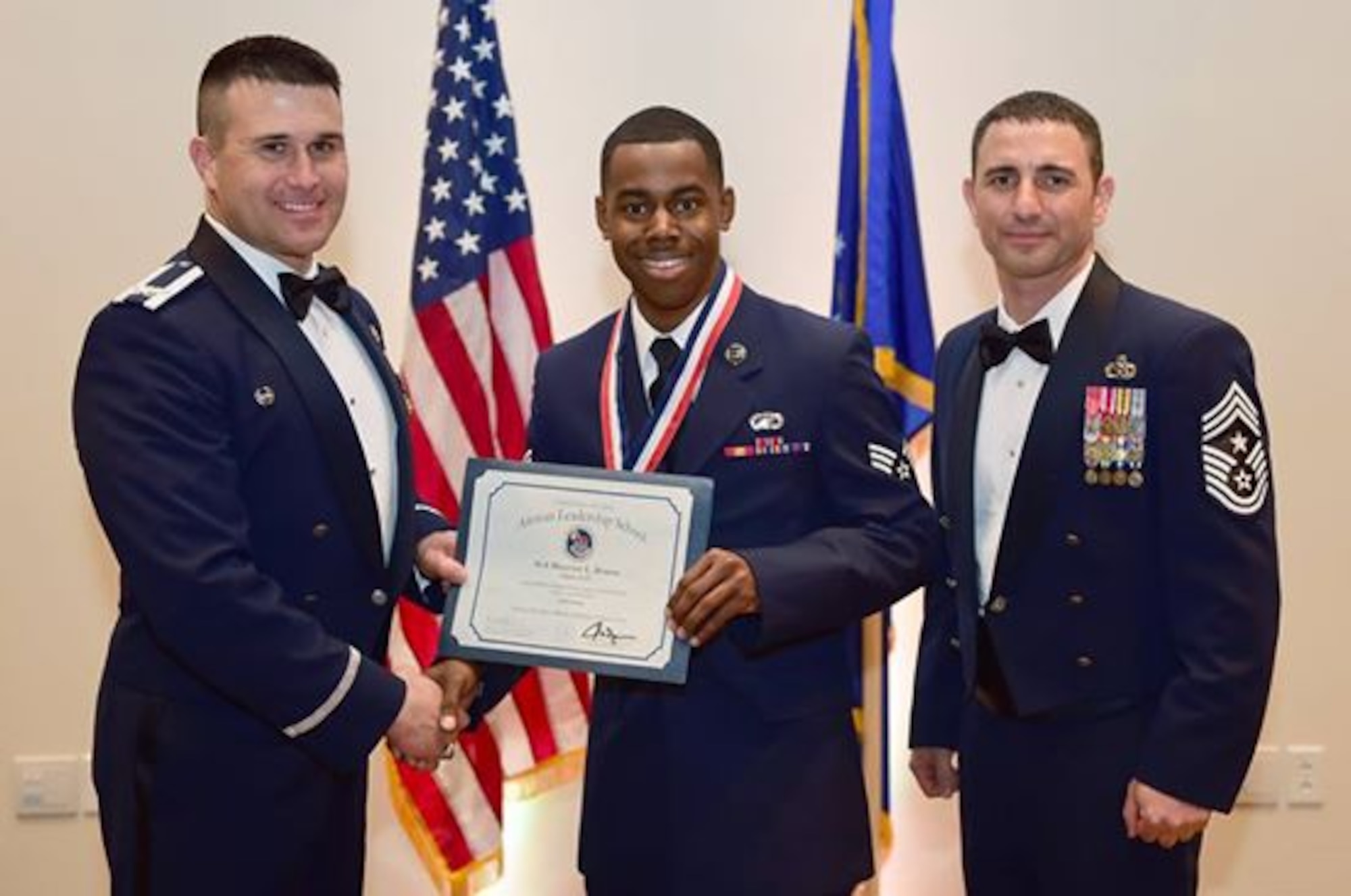 Col. John Wagner, 460th Space Wing commander, and Chief Master Sgt. Brian Kruzelnick, 460th Space Wing command chief, congratulate Senior Airman Maurice Brown, Air Reserve Personnel Center DD Form 214 technician, during the Team Buckley's Annual Awards ceremony March 26, 2015, at the Leadership Development Center on Buckley Air Force Base, Colo. This graduation represents an important part of the enlisted force professional military education, teaching valuable skills required for supervisors. (U.S. Air Force photo by Airman 1st Class Luke Nowakowski/Released)