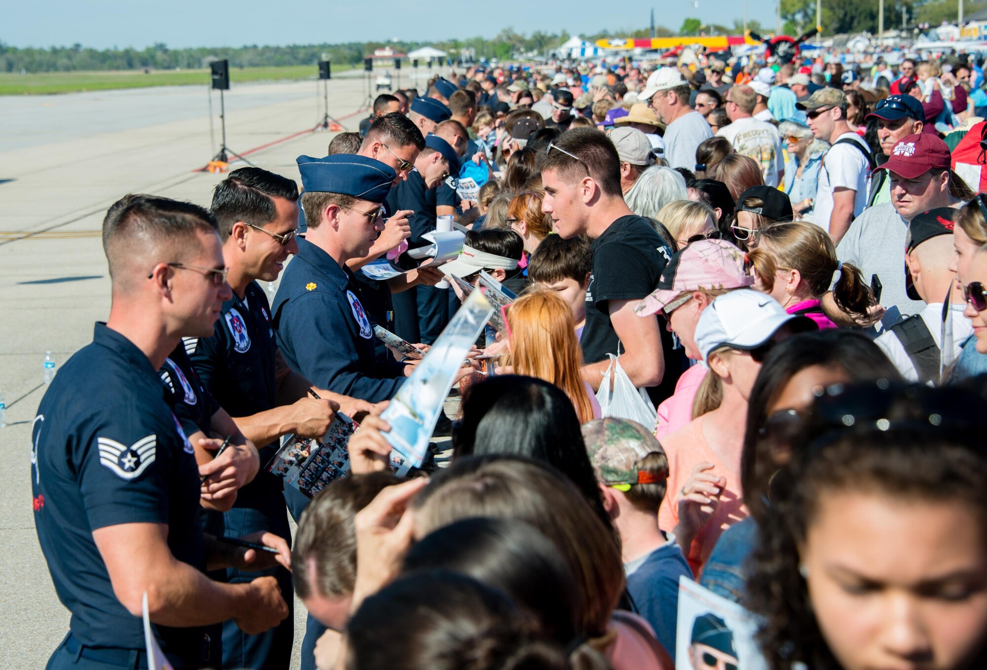 The U.S. Air Force Thunderbirds autograph Thunderbirds programs during Keesler’s 2015 Air Show/Open House March 28, 2015, at Keesler Air Force Base, Mississippi. The Thunderbirds headlined the two-day event held March 28-29. The event included the U.S. Air Force Thunderbirds and Army Golden Knights along with many other performers, static displays and vendors. Approximately 155,000 people were in attendance for the two-day show. (U.S. Air Force photo by Marie Floyd)