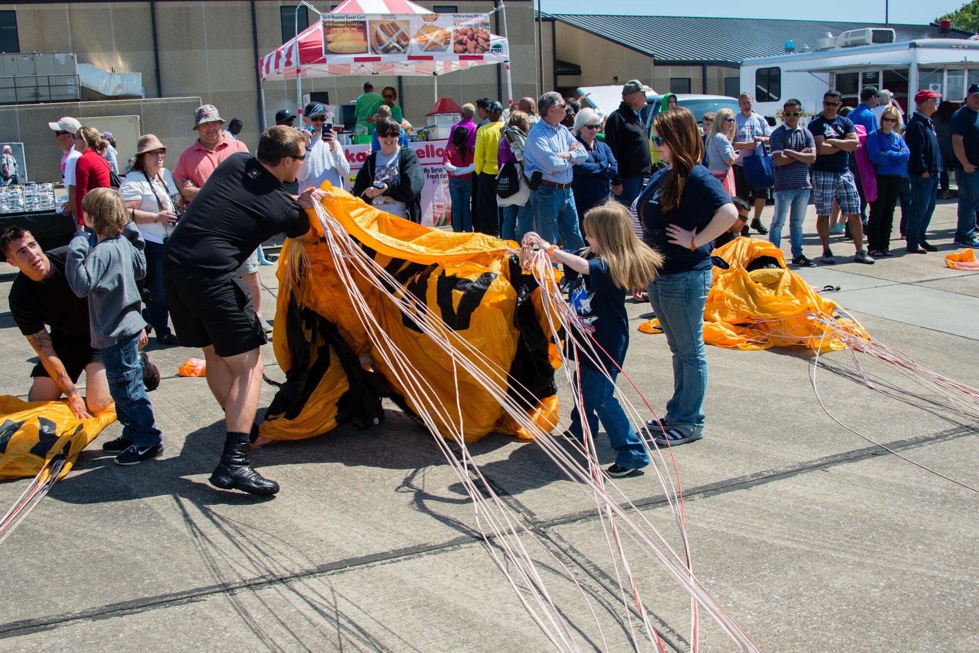 Army Sergeant Luke Olk, a member of the U.S. Army Golden Knights parachute team, opens a parachute to show attendees during the Keesler Air Force Base, Mississippi, Air Show/Open House March 28, 2015. The event included the U.S. Air Force Thunderbirds and Army Golden Knights along with many other performers, static displays and vendors. Approximately 155,000 people were in attendance for the two-day show. (U.S. Air Force photo by Marie Floyd)