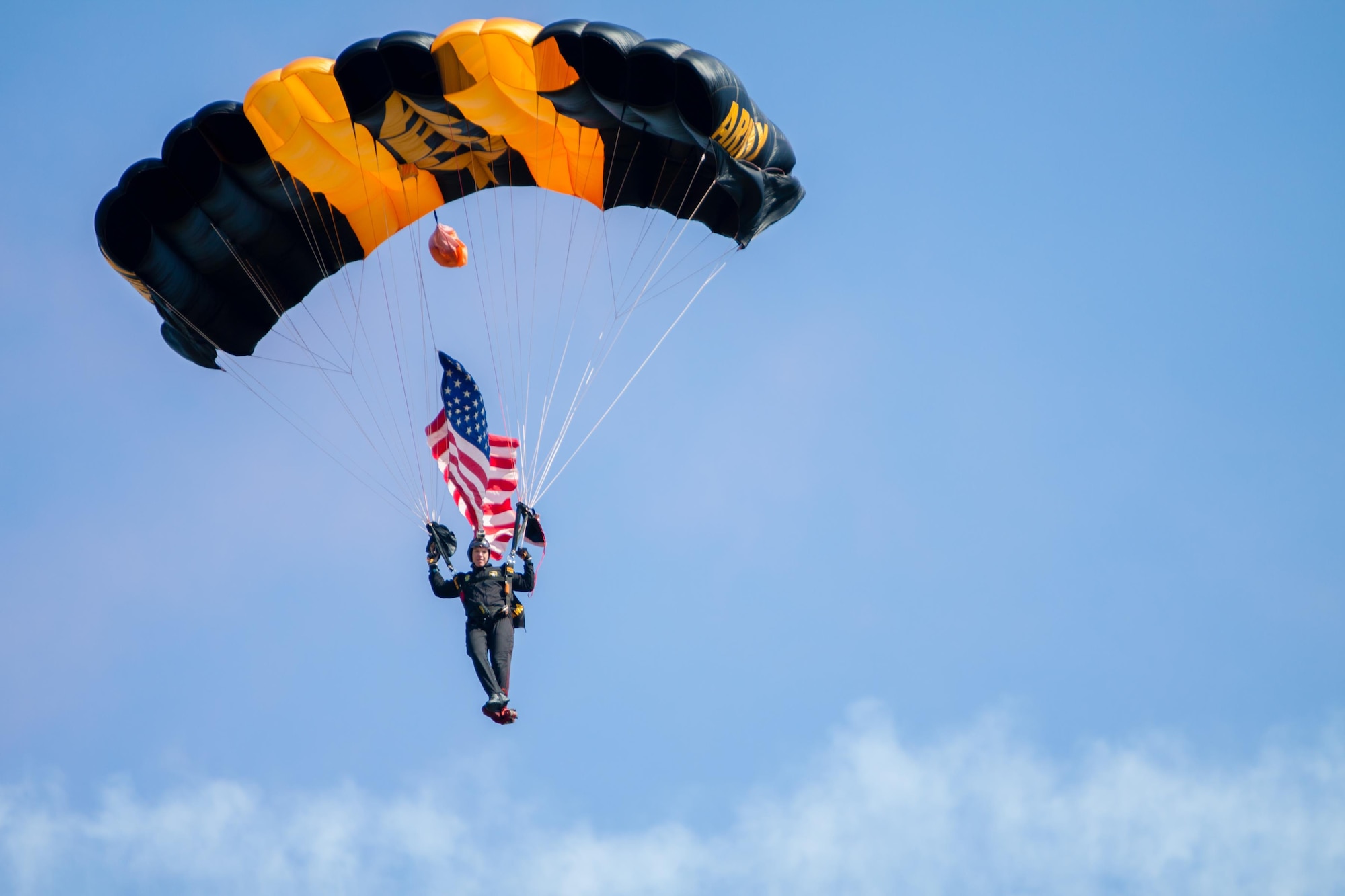 Army Staff Sergeant James Hackett, a member of the U.S. Army Golden Knights parachute team, carries the U.S. flag during opening ceremonies for the Keesler Air Force Base, Mississippi Air Show/Open House, March 28, 2015. The event included the U.S. Air Force Thunderbirds and Army Golden Knights along with many other performers, static displays and vendors. Approximately 155,000 people were in attendance for the two-day show. (U.S. Air Force photo by Marie Floyd)