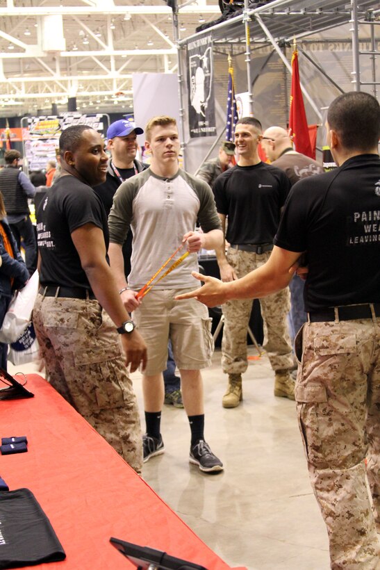 Greg Packard ,center, took some time to speak to Recruiting Station Cleveland recruiters, U.S. Marine Corps Sgts. Tevin Ammons, left, from Lorain, Ohio, and  Johnathan Vasquez, right, a native of Cleveland, Ohio, after preforming pull-ups during the Summit Racing Equipment 49th Annual I-X Piston Powered Auto-Rama, held at the I-X Center in Cleveland, March 22, 2015. Packard, a resident of Sheffield Village, Ohio, performed 11 pull-ups to earn a lanyard before learning more about the opportunities in the Marine Corps from the local recruiters. (U.S. Marine Corps photo by Sgt. T. M. Stewman/Released)
