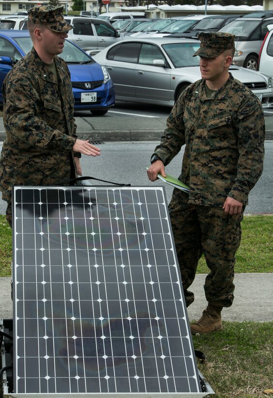 1st Lt. Stephen Stavish, left, and 1st Lt. James Patterson, right, observe and discuss the use of a solar panel after an energy efficiency briefing  Feb. 26 outside the Camp Foster Theater on Okinawa. The panels, an element of the Ground Renewable Expeditionary Energy Network, use energy taken from the sun and convert it into electricity. The panels provide alternative power options for energizing communications equipment, computers, and other electronic equipment in an expeditionary environment. Stavish is a native of Watchung, N.J. and an operations officer with 3rd Transportation Support Battalion, Combat Logistics Regiment 3, 3rd Marine Logistics Group, III Marine Expeditionary Force. Patterson is a native of San Antonio, Texas and logistics officer with 3rd TSB, 3rd MLG, III MEF.