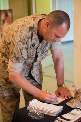 Sgt. Maj. Kevin Williamson fills out a contribution form for the Navy-Marine Corps Relief Society Active Duty Fund Drive March 16 at the Camp Foster Community Center. The NMCRS provides financial relief to active duty and retired Marines and sailors as well as their eligible surviving family members through interest-free loans and grants. A large portion of those loans and grants are raised through the ADFD, which gives active duty military a chance to donate and help their fellow service members in need. Williamson is the sergeant major of Marine Corps Installations Pacific-Marine Corps Base Camp Butler, Japan. 