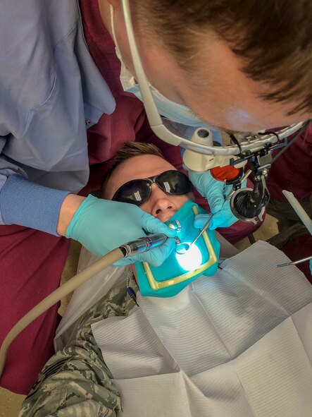 Capt. Brian Blackwell, a 92nd Aerospace Medicine Squadron general dentist, removes decayed root canal material that has discolored the tooth of Staff Sgt. Benjamin W. Stratton, a 92nd Air Refueling Wing public affairs photojournalist, in the base dental clinic at Fairchild Air Force Base, Wash., March 16, 2015. As a general dentist, Blackwell is able to be patient-focused providing high-end dental care to Fairchild’s Airmen. (U.S. Air Force photo/Staff Sgt. Benjamin W. Stratton)