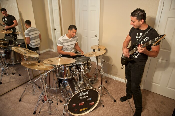 Senior Airmen Leonel and Anibal DeJesus-Martinez, both F-22 Raptor integrated avionics technicians assigned to the 57th Aircraft Maintenance Squadron, play music together in their home in Las Vegas, March 25, 2015. The brothers have used their sibling rivalry to push each other throughout their lives, but take time to collaborate as well. (U.S. Air Force photo by Staff Sgt. Victoria Sneed)