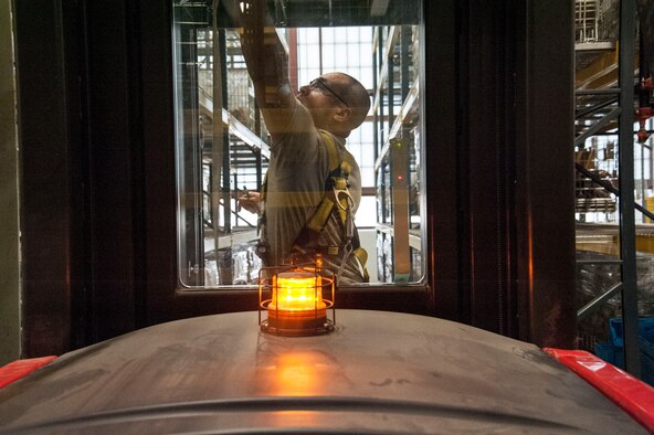Staff Sgt. Micheal Heger, 92nd Logistics Readiness Squadron Individual protective equipment supervisor, attaches his harness to a Raymond 3K stock picker March 26, 2015, at Fairchild Air Force Base, Wash. Heger conducts inventories on everything in the warehouse including 100 percent accountability of more than 1,000 weapons, more than 40,000 assorted chemical protective equipment items and more than 1,000 M50 gas masks. (U.S. Air Force photo/Staff Sgt. Samantha Krolikowski)