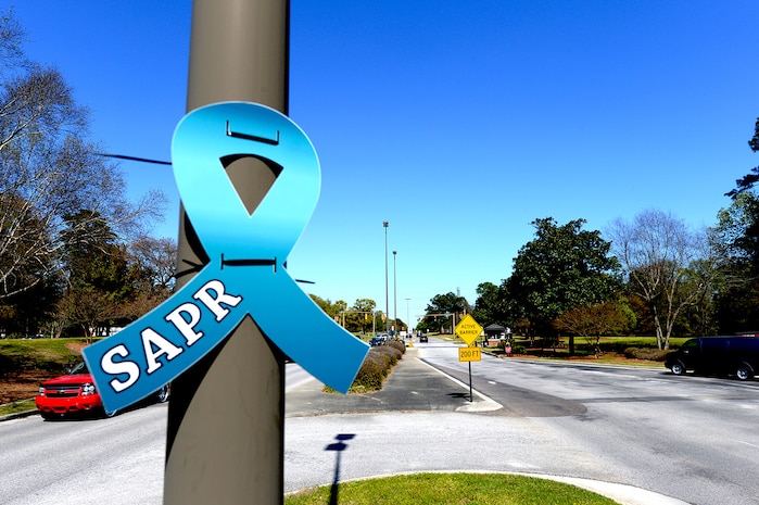 Approximately 10 members from the 628th Civil Engineer Squadron placed teal Sexual Assault Prevention and Response awareness ribbons on light posts at Joint Base Charleston Air Base's front and back gates March 31, 2015. The 628th Air Base Wing declared the month of April 2015 as Sexual Assault Awareness Month for Team Charleston. The teal ribbons symbolize the start of SAAM.  (U.S. Air Force photo by Senior Airman Christopher Reel)