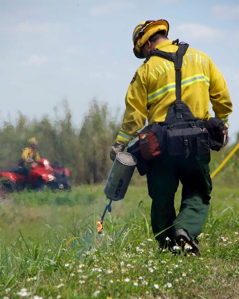 Luis Pineda, Florida Department of Forestry Service forest ranger, uses a fire can containing kerosene to light specific areas of the base on fire during a prescribed burn at Homestead Air Reserve Base, Florida, March 30. The prescribed burn was conducted to reduce the naturally occurring fuel load like leaves and underbrush, increase visibility in thick vegetative areas, control invasive species, and reduce the large mammal wildlife population. (U.S. Air Force photo by Staff Sgt. Jaimi L. Upthegrove)