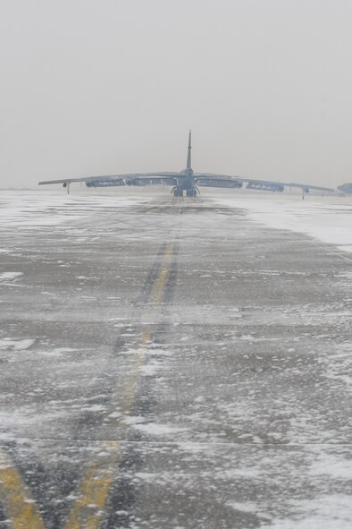 Snow blows across the flightline behind a B-52H Stratofortress during a rapid launch exercise on Minot Air Force Base, N.D., March 27, 2015. The base conducts exercises in a variety of weather conditions to test the response capabilities of both aircrew and ground personnel. (U.S. Air Force photo/Senior Airman Stephanie Morris)