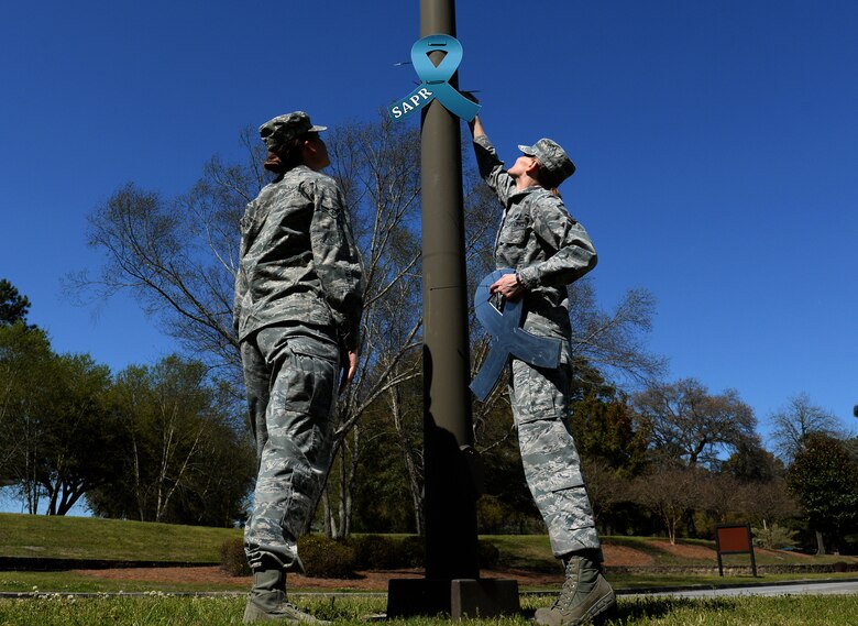 Members from the 628th Civil Engineer Squadron placed teal awareness Sexual Assault Prevention and Response ribbons on light posts at Joint Base Charleston Air Base's front and back gates March 31, 2015. The 628th Air Base Wing declared the month of April 2015 as Sexual Assault Awareness Month for Team Charleston. (U.S. Air Force photo by Senior Airman Christopher Reel)