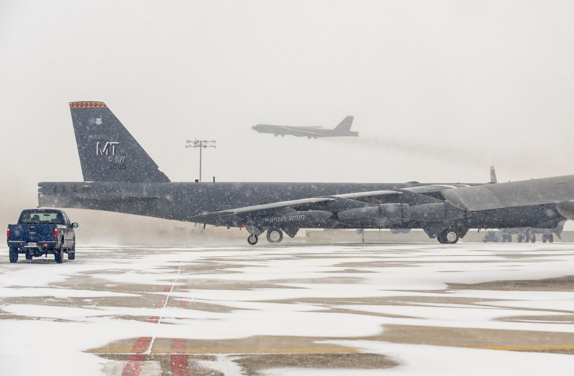 The 5th Bomb Wing’s “flag ship” B-52H Stratofortress taxis into position as another B-52 takes off during a rapid launch exercise on Minot Air Force Base, N.D., March 27, 2015. During the exercise, several B-52s took off in rapid succession. (U.S. Air Force photo/Senior Airman Stephanie Morris)