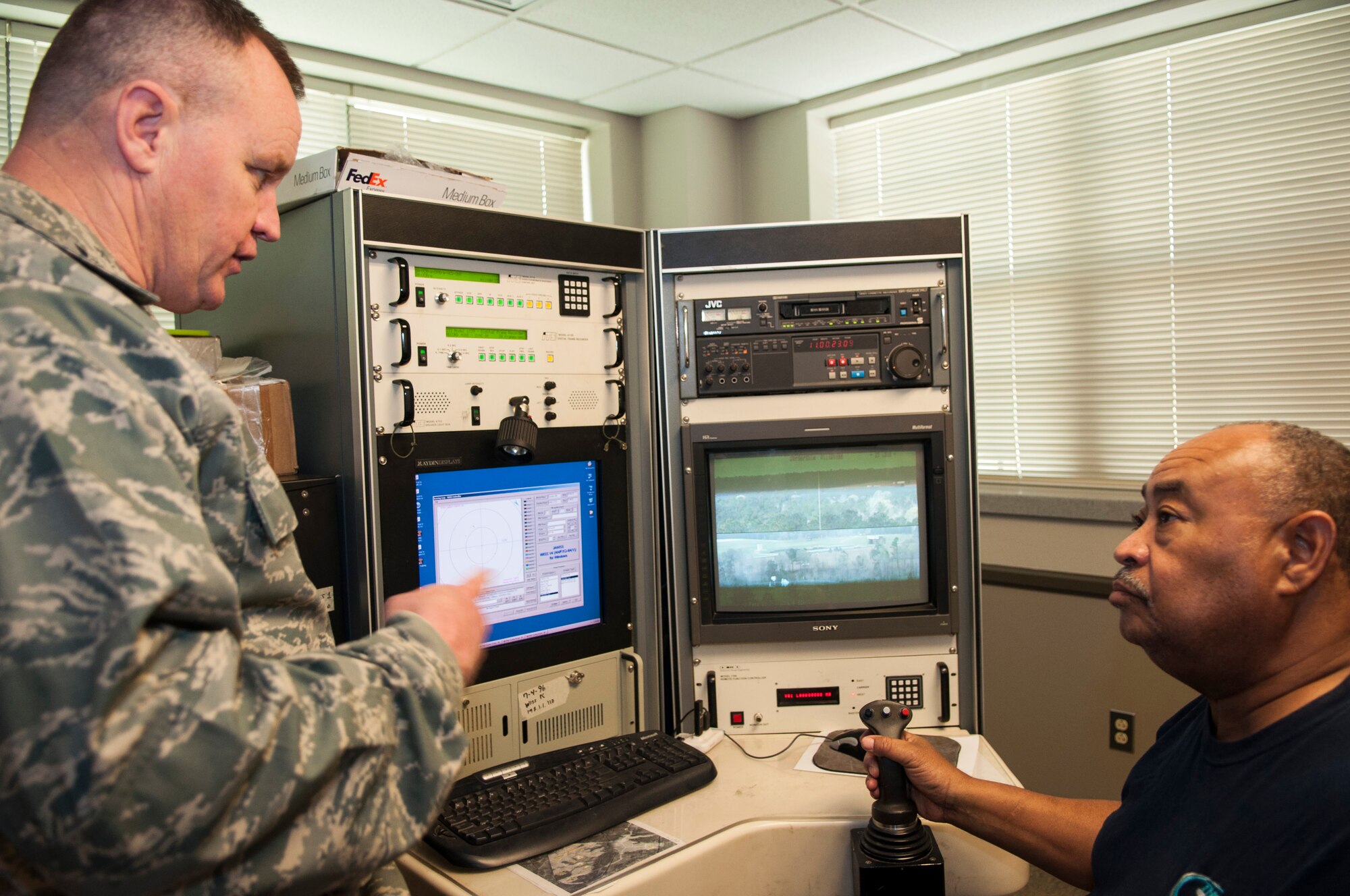 U.S. Air Force Colonel Bruce Cox, the commander of the 307th Bomb Wing, asks a civilian contractor about his job operating the Joint Threat Emitter at the Claiborne Range in Louisiana on March 25, 2015. Claiborne Range provides aircrews the opportunity to receive real time Electronic Countermeasure training and also acts as a conventional bombing, exercise and target range for all branches of the military. (U.S. Air Force photo by Master Sgt. Dachelle Melville/Released)