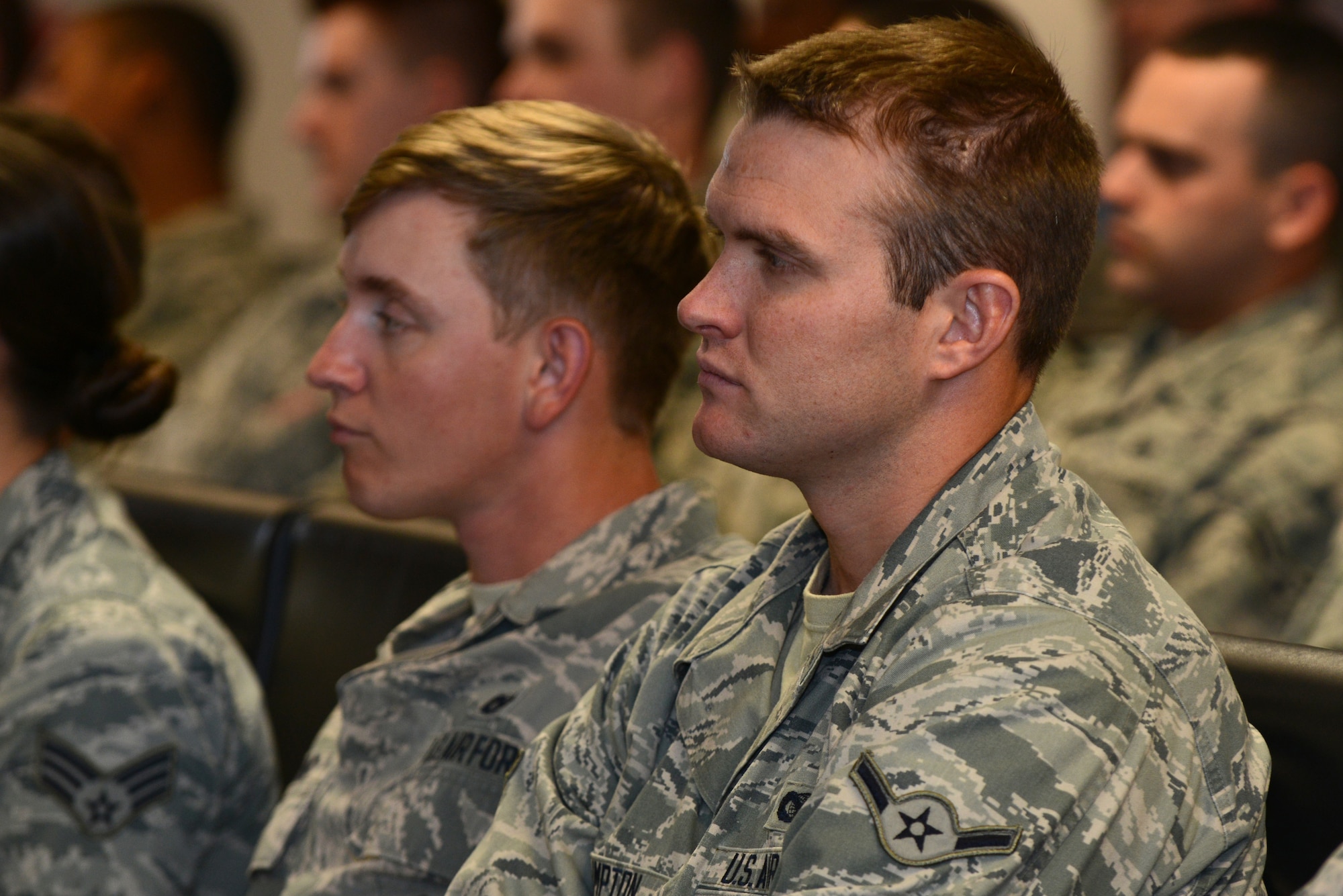 U.S. Air Force Airman Kyle Crumpton, 824th Base Defense Squadron fire team member, listens to Dr. Howard Wasdin, former Navy SEAL Team Six member, March 27, 2015, at Moody Air Force Base, Ga. Wasdin spoke to the 820th Base Defense Group about his time as a SEAL and his life after the military. (U.S. Air Force photo by Airman 1st Class Kathleen D. Bryant/Released)