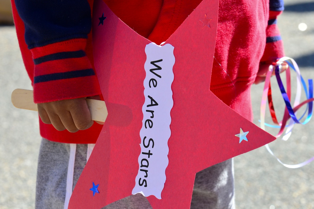 A child from the Pershing Child Development Center holds a sign during a parade celebrating the Month of the Military Child at Fort Eustis, Va., April 1, 2015. According to the National Child Traumatic Stress network, military children experience unique challenges related to military life and culture including deployment related stressors such as parental separation, family reunification and reintegration. (U.S. Air Force photo by Senior Airman Kimberly Nagle/Released)

