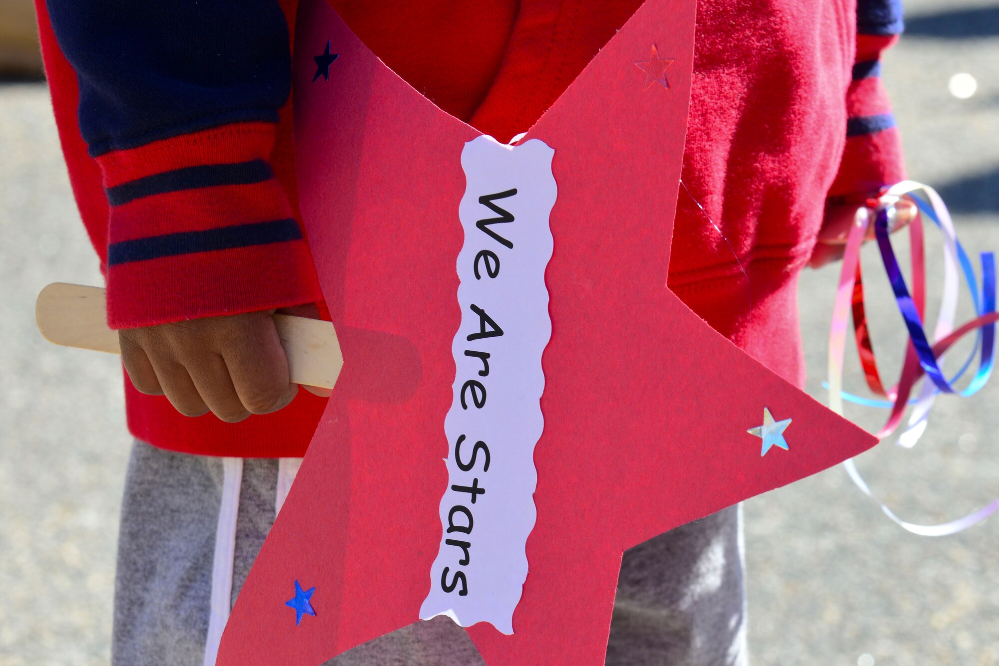 A child from the Pershing Child Development Center holds a sign during a parade celebrating the Month of the Military Child at Fort Eustis, Va., April 1, 2015. According to the National Child Traumatic Stress network, military children experience unique challenges related to military life and culture including deployment related stressors such as parental separation, family reunification and reintegration. (U.S. Air Force photo by Senior Airman Kimberly Nagle/Released)
