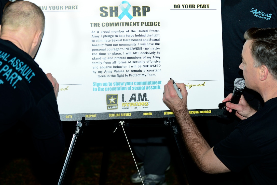 U.S. Army Col. Randal Nelson, 7th Transportation Brigade (Expeditionary) commander, left, and Col. William Galbraith, 733rd Mission Support Group commander, sign a commitment pledge before a Sexual Assault Awareness and Prevention Month 5K run at Fort Eustis, Va., April 1, 2015. The Department of Defense theme for this year’s SAAM is “Eliminate Sexual Assault: Know your part. Do your part.” (U.S. Air Force photo by Senior Airman Kimberly Nagle/Released)