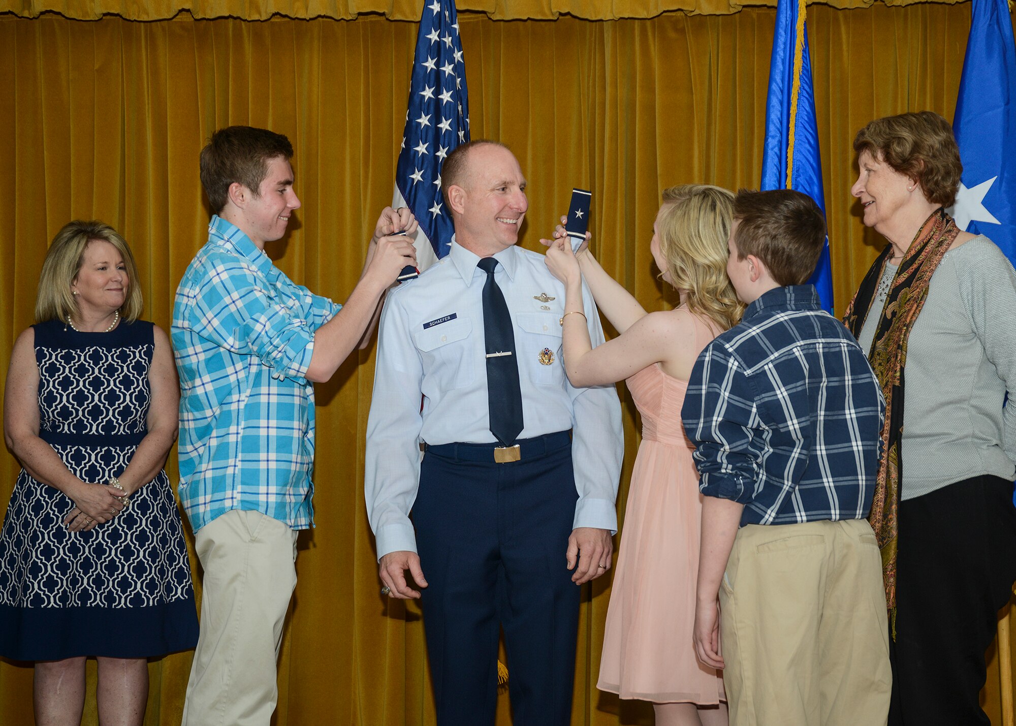 Brig. Gen. Carl Schaefer, 412th Test Wing commander, received his new rank during a promotion ceremony March 30 at Club Muroc. His jacket epaulettes were pinned on by his wife Pauline (left) and his mother Arlene (far right). His shirt epaulettes were pinned on by his son Colin and daughter Elise. His youngest, Caleb, pinned the new rank on his hat.(U.S. Air Force photo by Rebecca Amber)