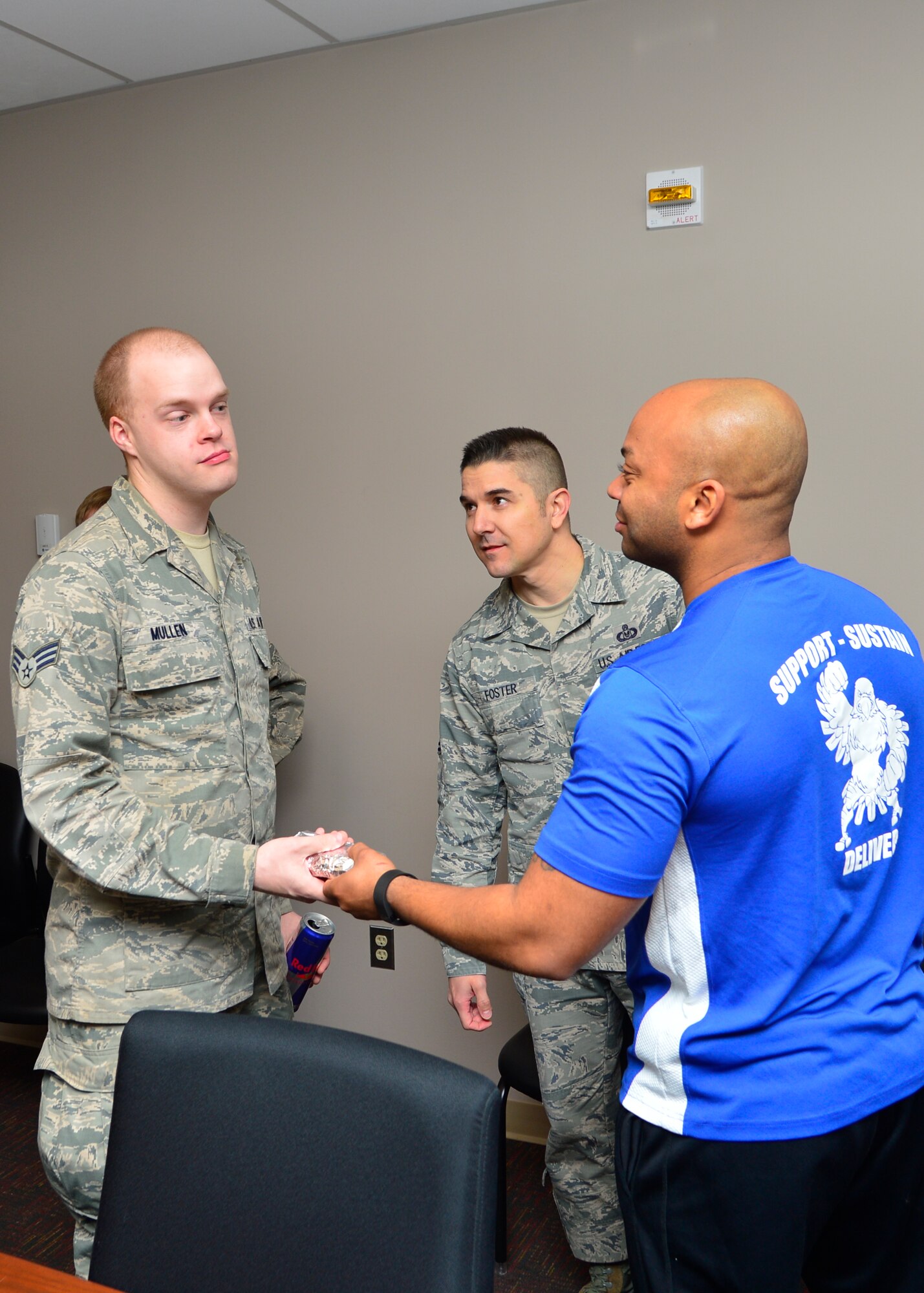 Senior Airman Cameron Mullen, 436th Operations Support Squadron Aircrew Flight Equipment technician, left, is handed a free breakfast burrito from Master Sgt. Jamie Beard, 436th OSS AFE flight chief, April 1, 2015, at Dover Air Force Base, Del. Volunteers from the Dover AFB Top 3 organization spent more than four hours preparing and distributing more than 900 breakfast burritos to Airmen in the ranks of E-4 and below across the base. (U.S. Air Force photo/Airman 1st Class William Johnson)