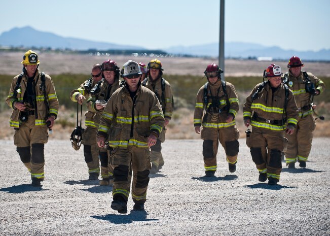 Firefighters from the Merced County Fire Department’s Castle Fire Station 62, Atwater, Calif., walk toward the burn pit during training at Nellis Air Force Base, Nev., March 27, 2015. The MCFD is responsible for responding to fires at Castle Airport, which was formerly Castle AFB, and trains at Nellis AFB every year to meet Federal Aviation Administration training requirements. (U.S. Air Force photo by Staff Sgt. Siuta B. Ika)