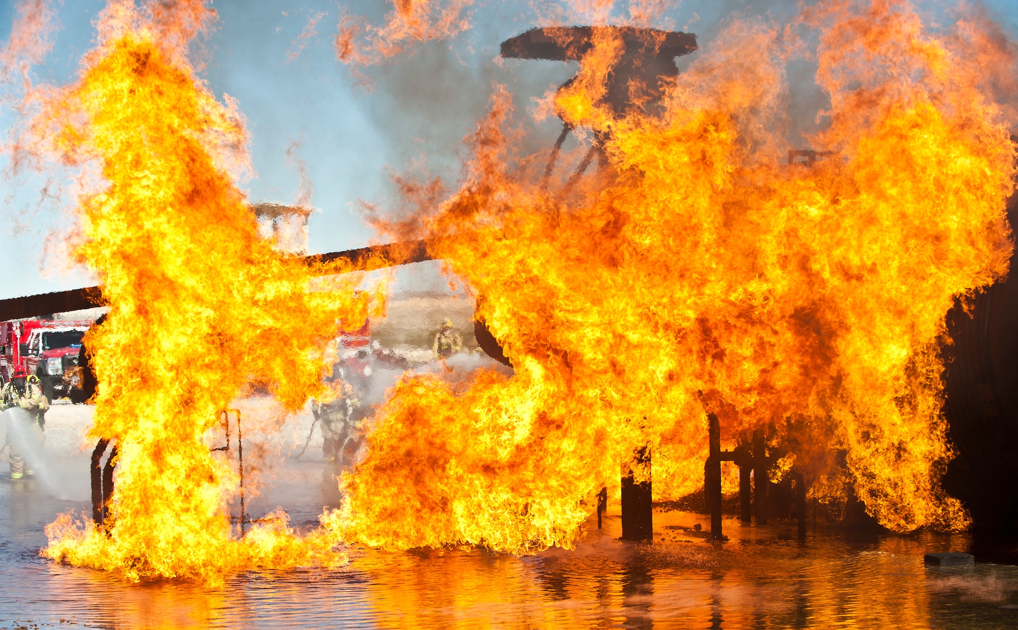 An aircraft fire rages during firefighter training at the burn pit on Nellis Air Force Base, Nev., March 27, 2015. Firefighters from the Merced County Fire Department’s Castle Fire Station 62, Atwater, Calif., joined the 99th Civil Engineer Squadron Fire Emergency Services Flight in extinguishing the fire. (U.S. Air Force photo by Staff Sgt. Siuta B. Ika)