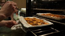 Jeffrey Moore, 436th Force Support Squadron, checks on the progress of baking sweet potatoes  March 31, 2015, at Dover Air Force Base, Del.The course teaches Airmen, who live in the dorms, how to cook healthy meals for themselves. (U.S. Air Force photo/Airman 1st Class Zachary Cacicia)