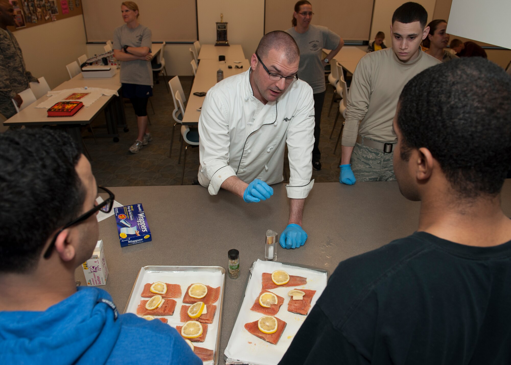 Jeffrey Moore, 436th Force Support Squadron, salts salmon March 31, 2015, at Dover Air Force Base, Del. Moore, a trained chef, taught the class how to prepare baked salmon with sautéed zucchini and squash, and roasted sweet potatoes. (U.S. Air Force photo/Airman 1st Class Zachary Cacicia)   