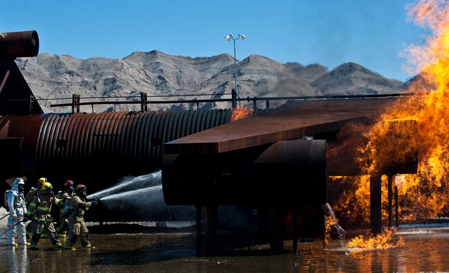 Firefighters from the Merced County Fire Department’s Castle Fire Station 62, Atwater, Calif., extinguish an aircraft fire during training at the burn pit on Nellis Air Force Base, Nev., March 27, 2015. The MCFD is responsible for responding to fires at Castle Airport, which was formerly Castle AFB, and trains at Nellis AFB every year to meet Federal Aviation Administration training requirements. (U.S. Air Force photo by Staff Sgt. Siuta B. Ika)