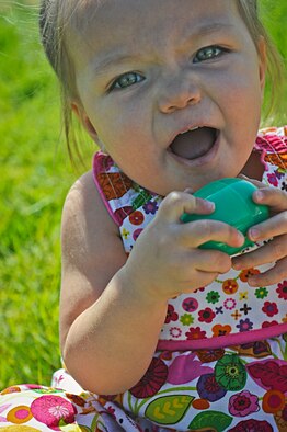Madelyn, 1, gathers eggs during an Easter egg hunt at Nellis Air Force Base, Nev., March 28, 2015. Approximately 10,000 Easter eggs were filled with toys and candy during the event, which was held at the Nellis AFB Youth Center’s baseball field. (U.S. Air Force photo by Staff Sgt. Darlene Seltmann)